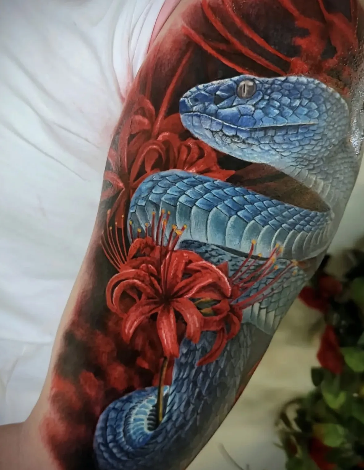 Detailed snake tattoo with vibrant red floral elements
